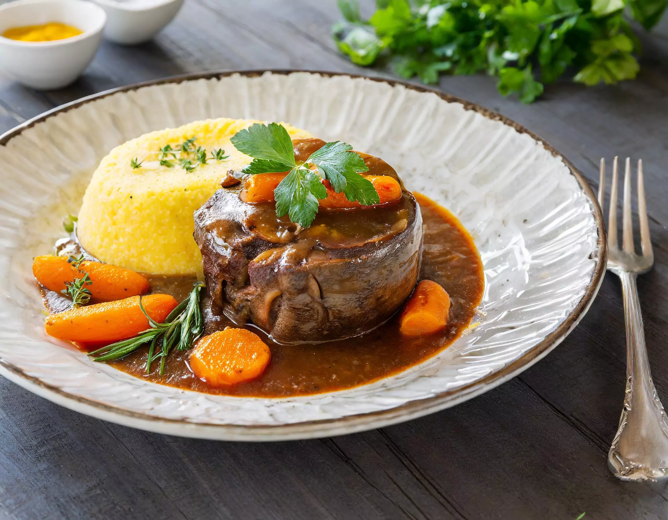 Rinderbraten mit Karotten und Polenta auf Teller