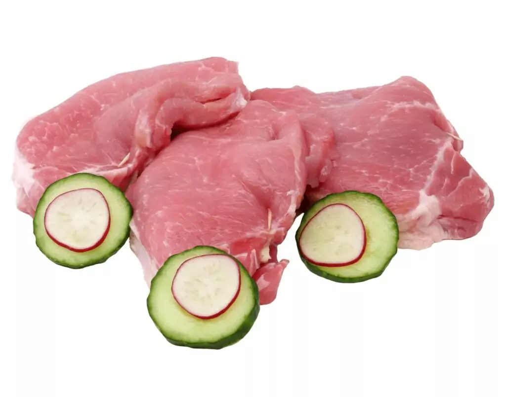 Drei rohe Schweineschnitzel, jeweils mit einer Gurkenscheibe, die eine dünne Scheibe Radieschen enthält, auf einem weißen Hintergrund.