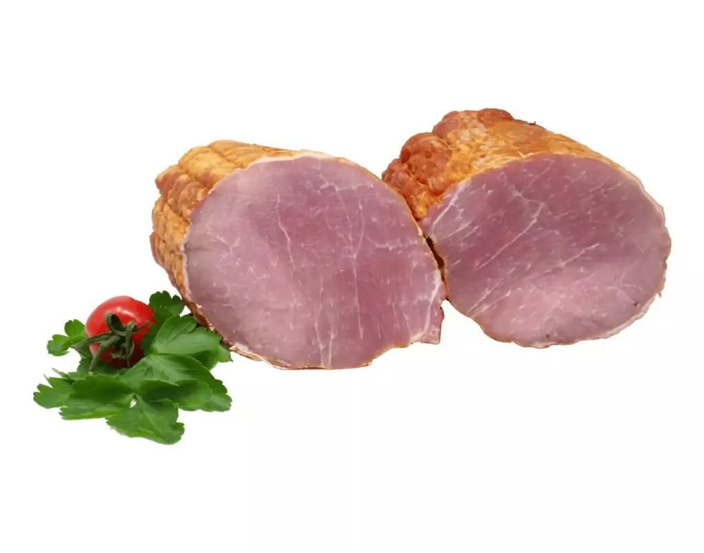 Zwei halbierte Stücke geräucherter Schinken mit glatter rosa Oberfläche, garniert mit frischer Petersilie und einer kleinen roten Tomate, auf weißem Hintergrund.
